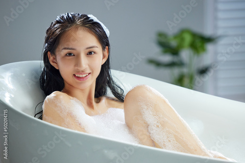 Washing hubble-bubble bath happy young woman