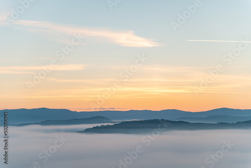 view of sunrise above mountains mist in the bottom © phpetrunina14