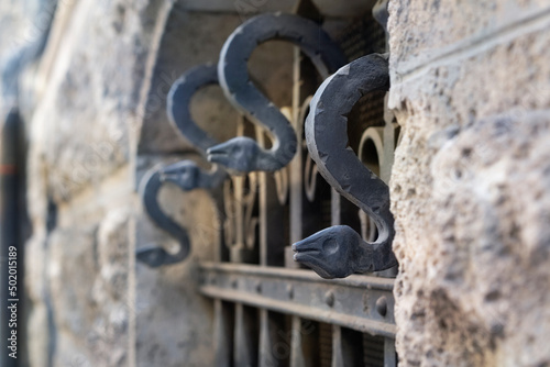 Window in an old house with decorative bars. Detail of a window lattice (grid). Old decorative forged metal elements.