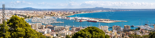 Panorama view from elevated castle Castell de Bellver over the bay of Palma de Mallorca with old town, cathedral La Seu, marina, harbor to the airport and famous beach Platja de Palma at the horizon.
