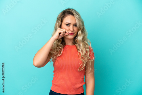 Young Brazilian woman isolated on blue background showing a sign of silence gesture