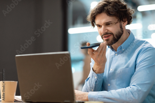 Smiling man working and talking on phone at office photo