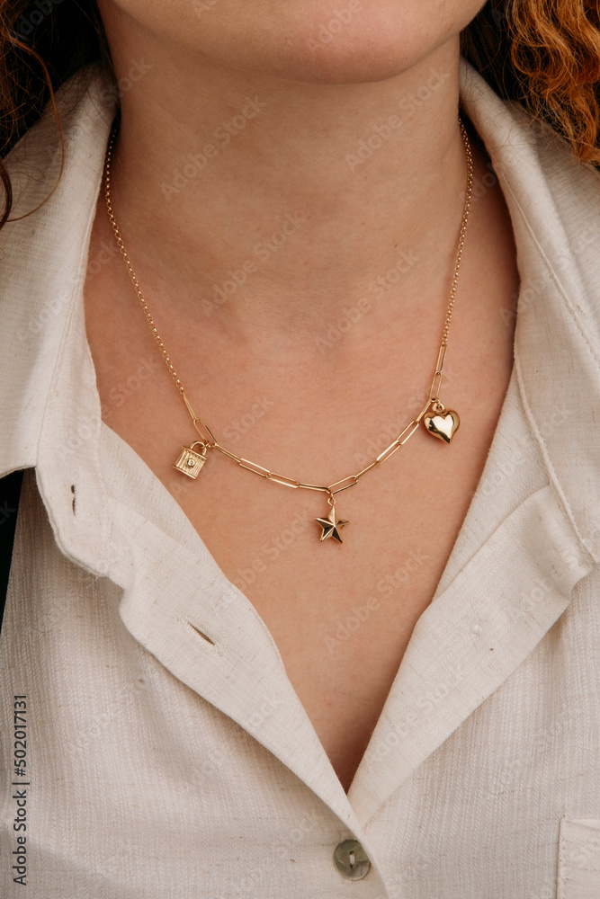 Close-up young woman wearing gold chain necklace. Modern fashion details. minimalist lifestyle