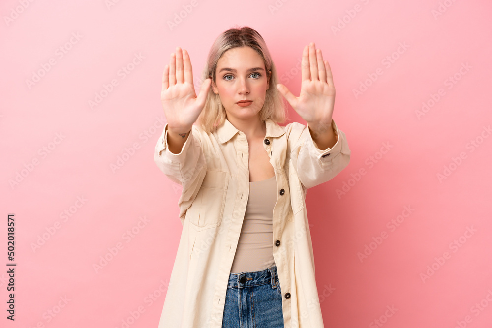 Young caucasian woman isolated on pink background making stop gesture and disappointed Young caucasian woman isolated on pink background making stop gesture and disappointed