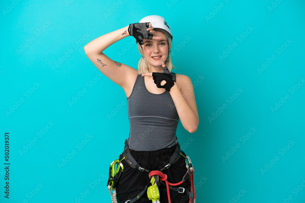 Young caucasian rock-climber woman isolated on white background focusing face. Framing symbol Young caucasian rock-climber woman isolated on white background focusing face. Framing symbol