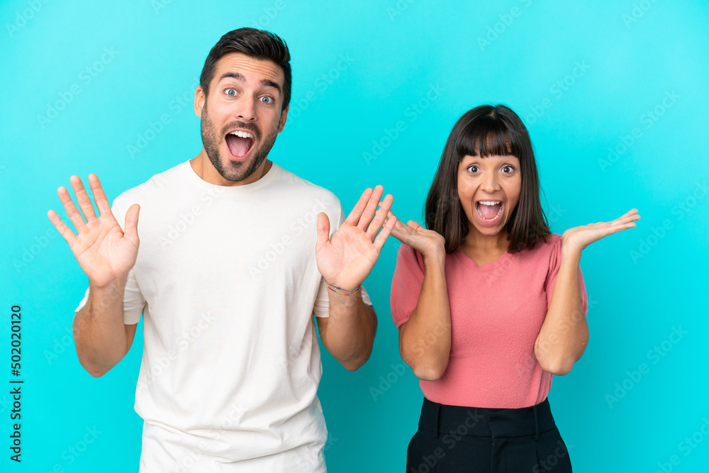 Young couple isolated on blue background with surprise and shocked facial expression Young couple isolated on blue background with surprise and shocked facial expression