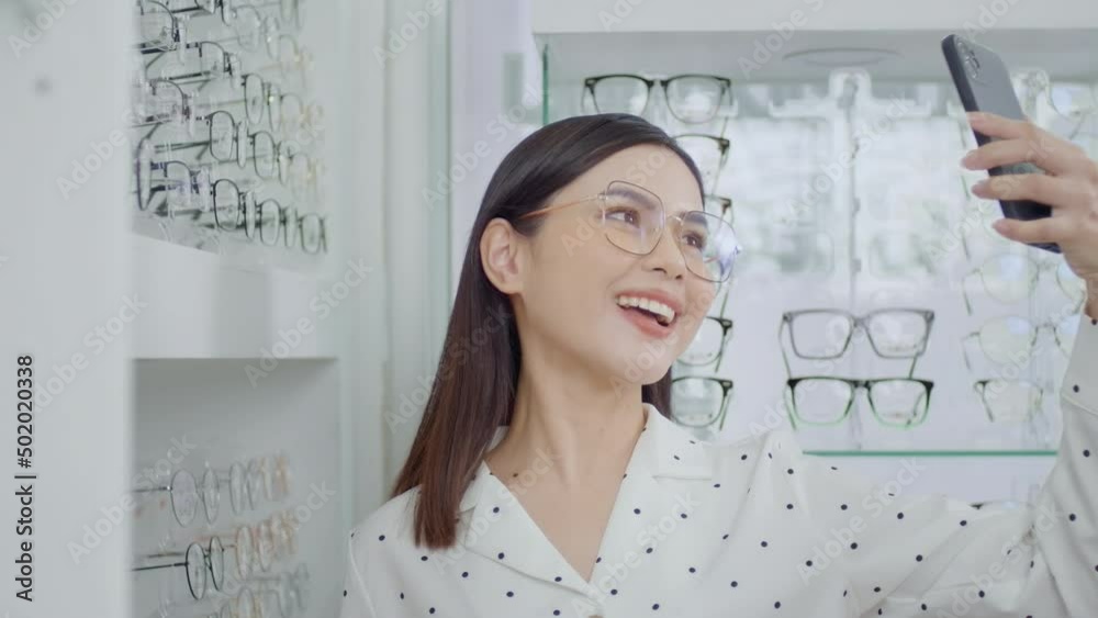 Young female customer trying on glasses and taking a selfie in optical center, Eyecare concept. Young female customer trying on glasses and taking a selfie in optical center, Eyecare concept.