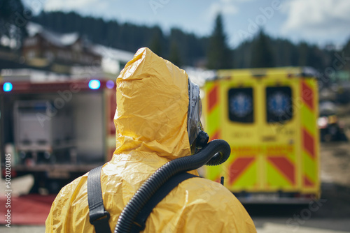 Εκτύπωση καμβά Member of biohazard team of emergency medical service in protective suit against ambulance and firefighters
