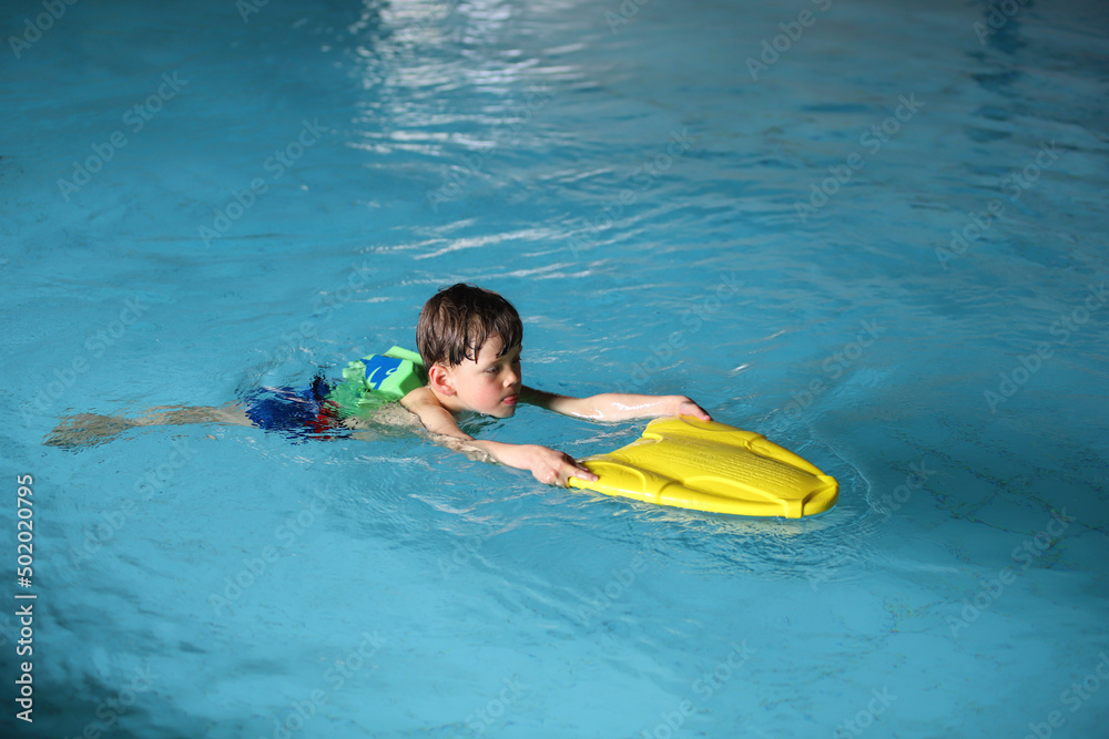 Ein kleiner Junge lernt Schwimmen