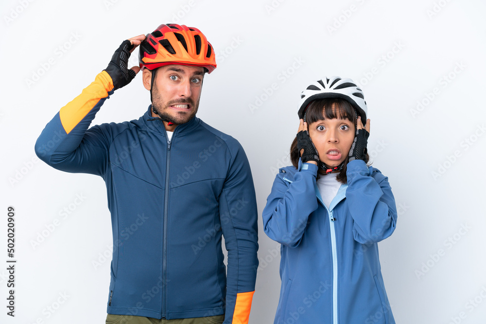 Young cyclist couple isolated on white background takes hands on head because has migraine