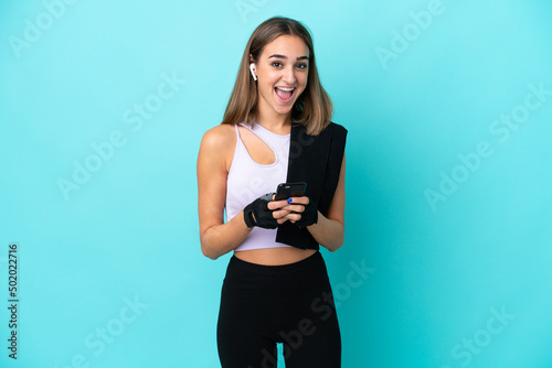 Young sport woman isolated on blue background surprised and sending a message