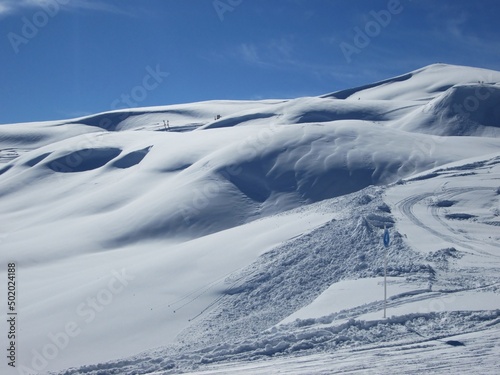 Winter landscape in Saint Sorlin d'Arves - Les Sybelles. Winter desert. Mountains against blue sky in French Alps. Sunny day in ski resort. Fun during holidays. Ski business. Alps and snow.  photo