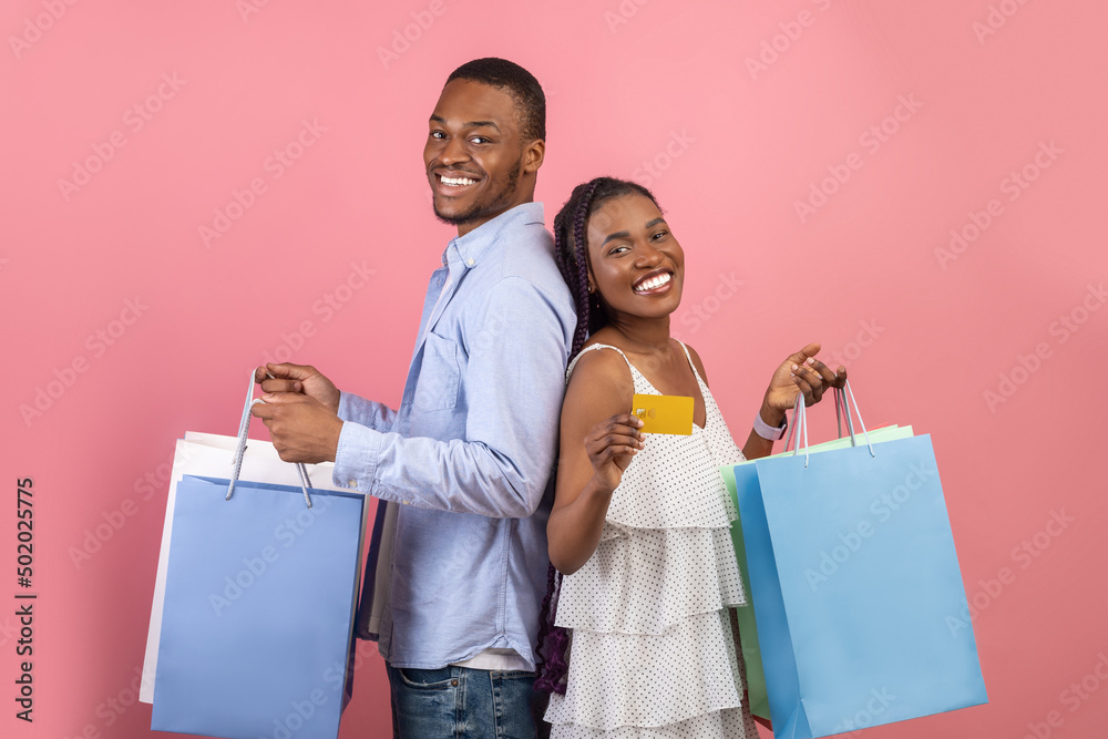 Portrait of happy black couple holding credit card and bags Portrait of happy black couple holding credit card and bags