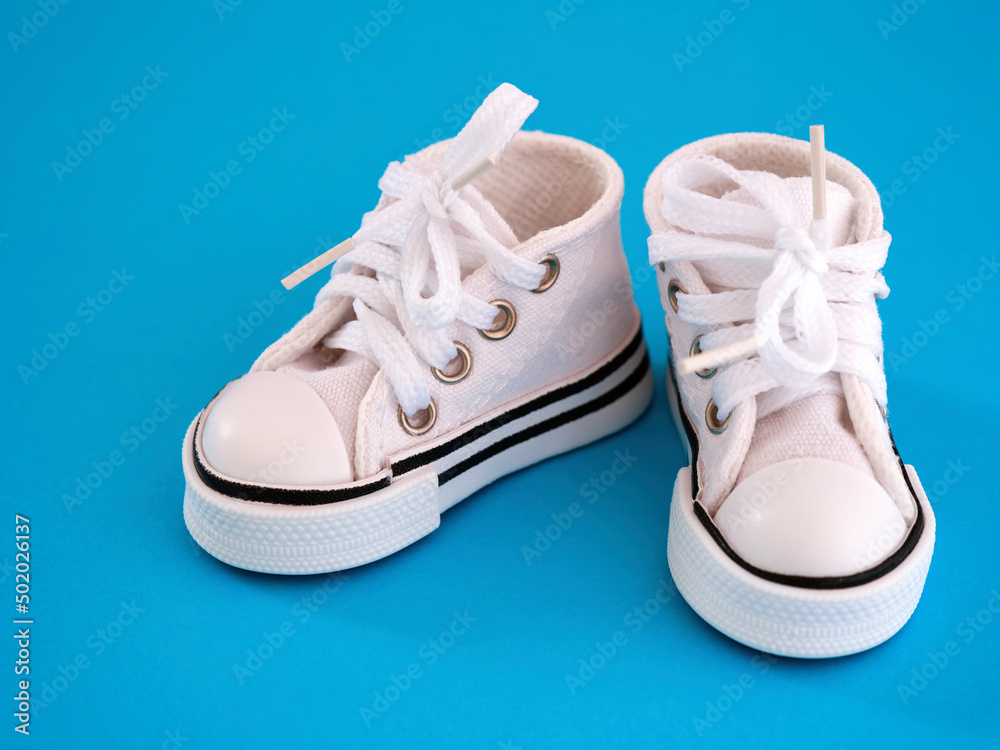 A white doll shoes on blue background