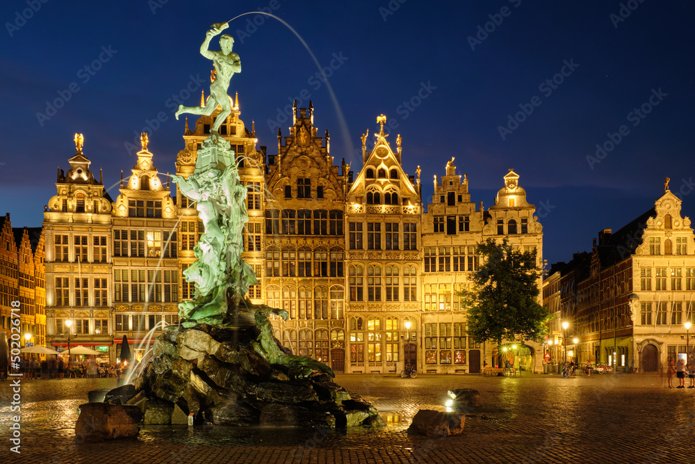 Antwerp famous Brabo statue and fountain on Grote Markt square illuminated at night and old houses. Antwerp, Belgium