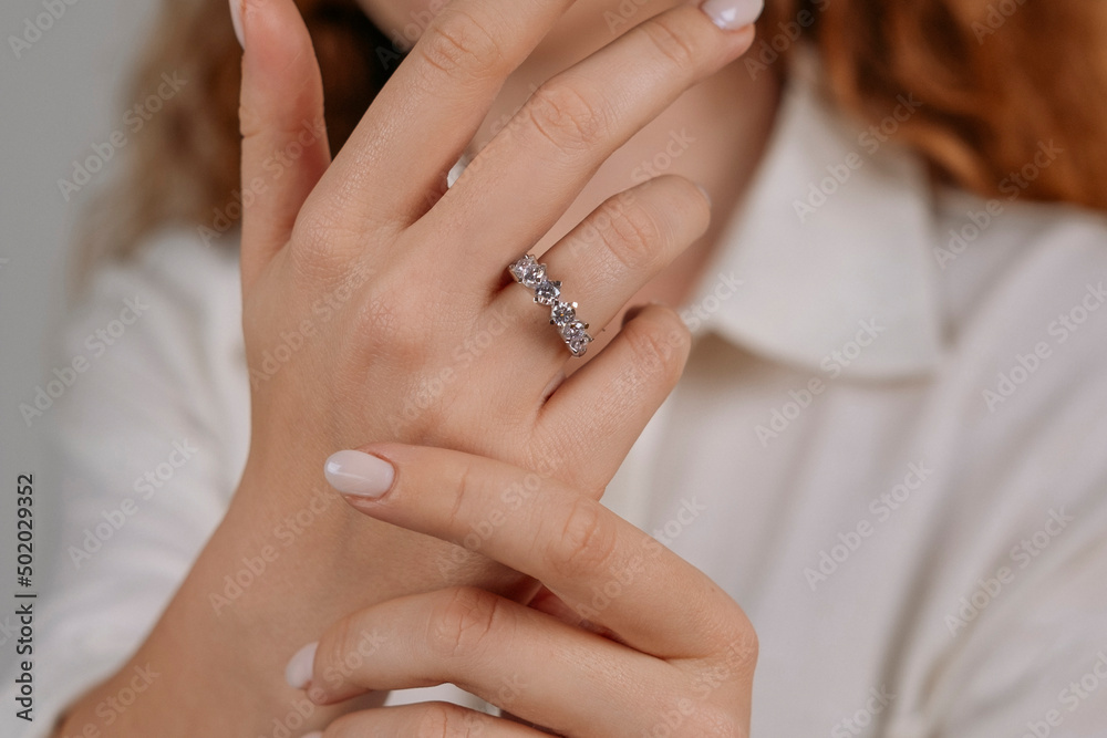 Golden Ring on a female hand, diamonds Diamond ring in hands of young lady. Close-up photo shoot Golden Ring on a female hand, diamonds Diamond ring in hands of young lady. Close-up photo shoot