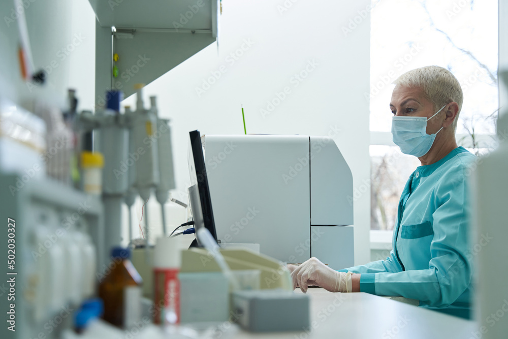 Mature woman working with pc in laboratory