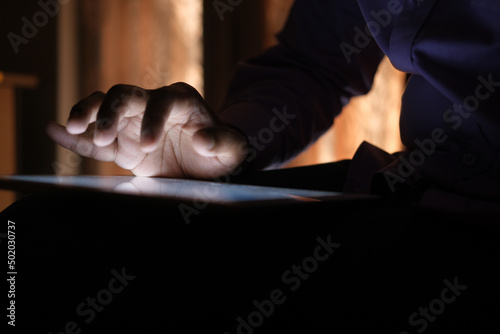  man hand using digital tablet on black background 