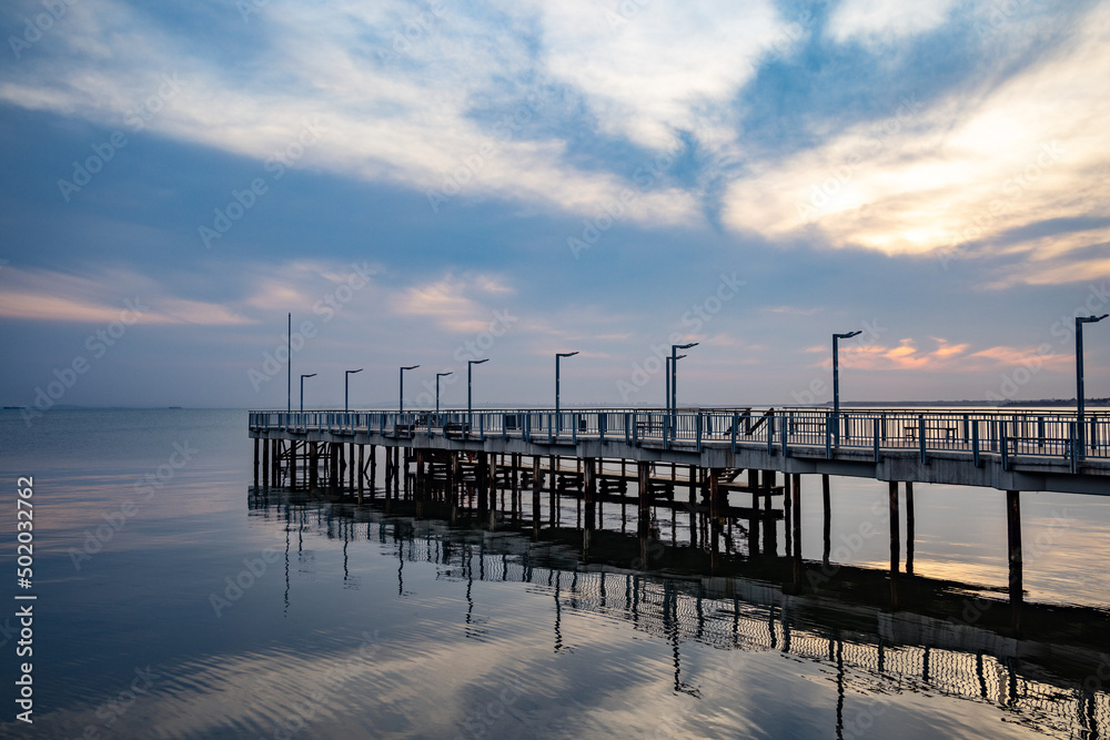 Fototapeta premium Side view of the pier on the Black Sea against the background of the sky and sunset