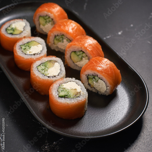 Philadelphia sushi roll with salmon, cucumber, avocado, cream cheese. Sushi menu. Japanese food