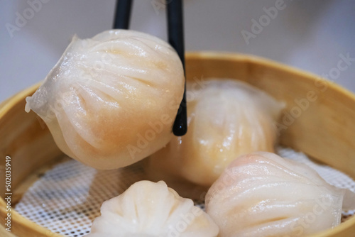 Принти на полотні extreme close up of chopsticks picking Har gow (Xia jiao) from steamer