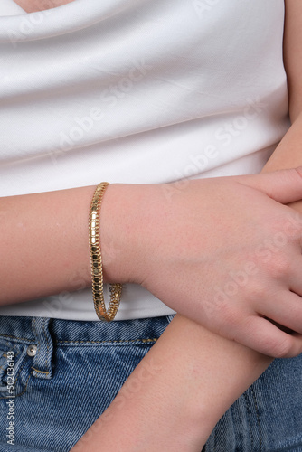 women's gold bracelet on the girl's hand, women's accessories, jewelry, gold bracelet with stones, women's jewelry, a girl with a bracelet on her arm, a bracelet with stones