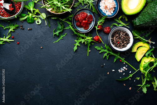 Healthy eating food layout and diet nutrition concept. Pineapple, vegetables, fruits, greens and other ingredients for salad preparation on black table background, copy spaсe