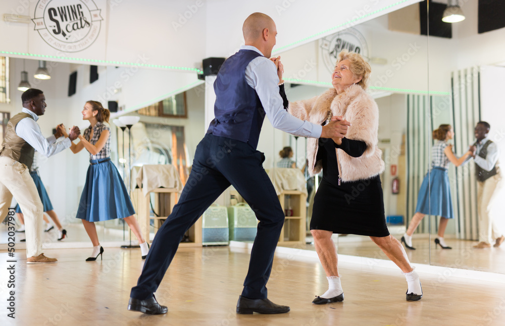 Fototapeta premium Two professional dancers practicing lindy hop in dance class