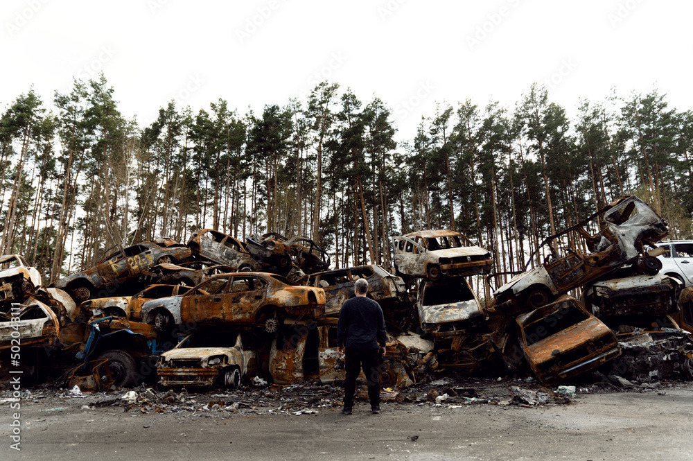 rusty burnt out cars destroyed from rocket explosions. fragments of bombs pierced cars. Russian vandalism in Ukraine. war in Ukraine. destroyed cars in Kyiv, bucha and irpen.