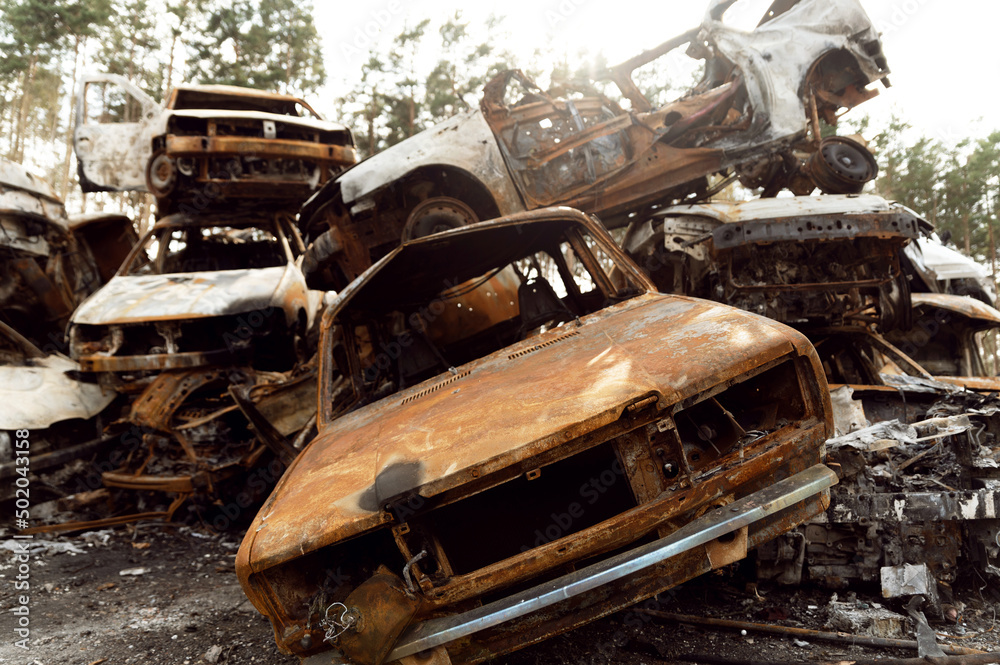 rusty burnt out cars destroyed from rocket explosions. fragments of bombs pierced cars. Russian vandalism in Ukraine. war in Ukraine. destroyed cars in Kyiv, bucha and irpen.