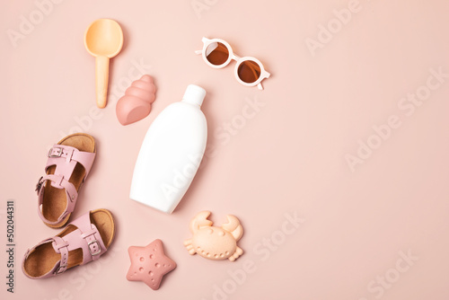 Kids summer accesories and sun screen bottle for sunny days and vacations. Sunglasses, sandals, sand molds for beach fun time