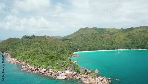 Aerial dolly over granite coast cape Anse Lazio toward to Petite beach