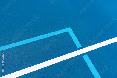 Blue tennis court with white lines and light blue pickleball lines. © Thomas
