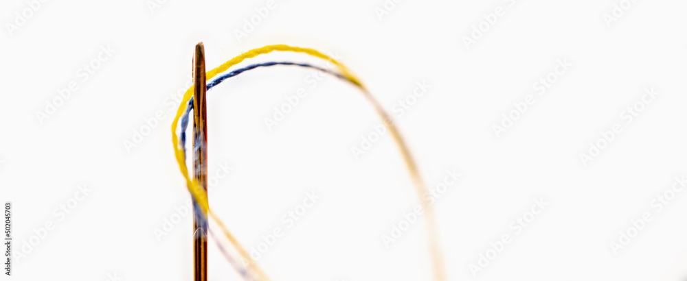 Yellow and blue threads as a symbol of the struggle of the Ukrainian people against russian aggression for their freedom and democracy. Copy space for design. Selective focus. Yellow and blue threads as a symbol of the struggle of the Ukrainian people against russian aggression for their freedom and democracy. Copy space for design. Selective focus.