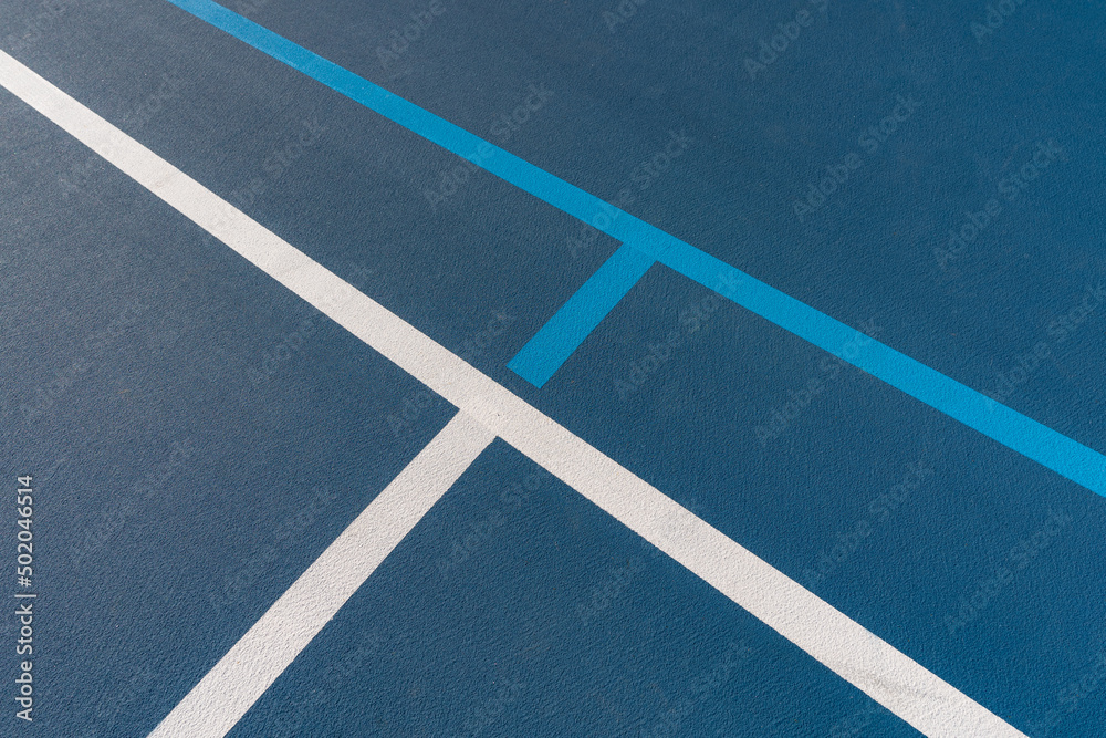 Blue tennis courts with white lines and light blue pickleball lines