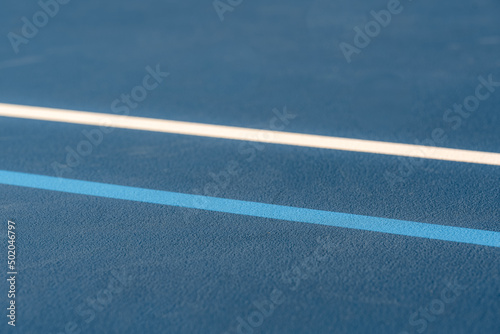 Blue tennis court with white lines and light blue pickleball lines © Thomas