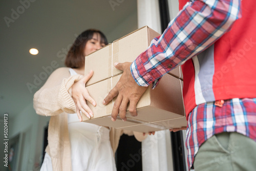 Delivery man delivering box to woman. © warodom