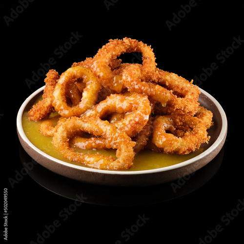 Squid rings in batter on a black background
