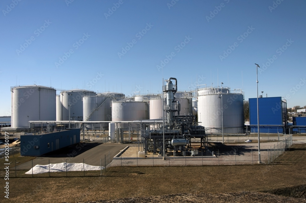 Big oil terminal in harbor with blue sky on background Big oil terminal in harbor with blue sky on background