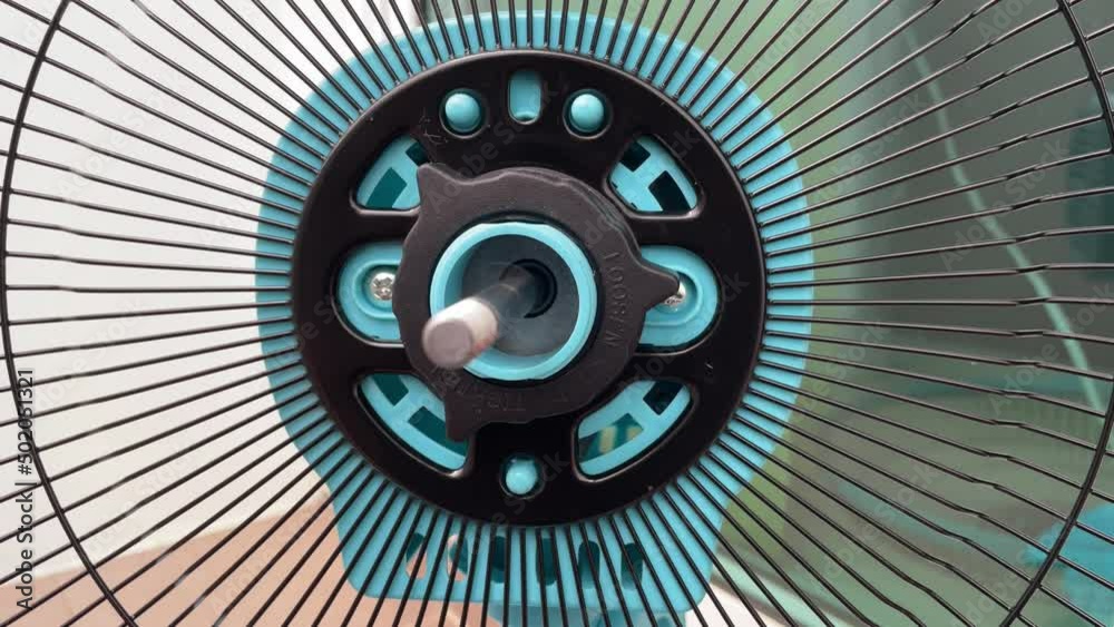Testing the bolt thread motor housing of electric fan. Turn on the fan and turn off view of rear grille metal bar of desk fan - DIY household self assembly concept Testing the bolt thread motor housing of electric fan. Turn on the fan and turn off view of rear grille metal bar of desk fan - DIY household self assembly concept