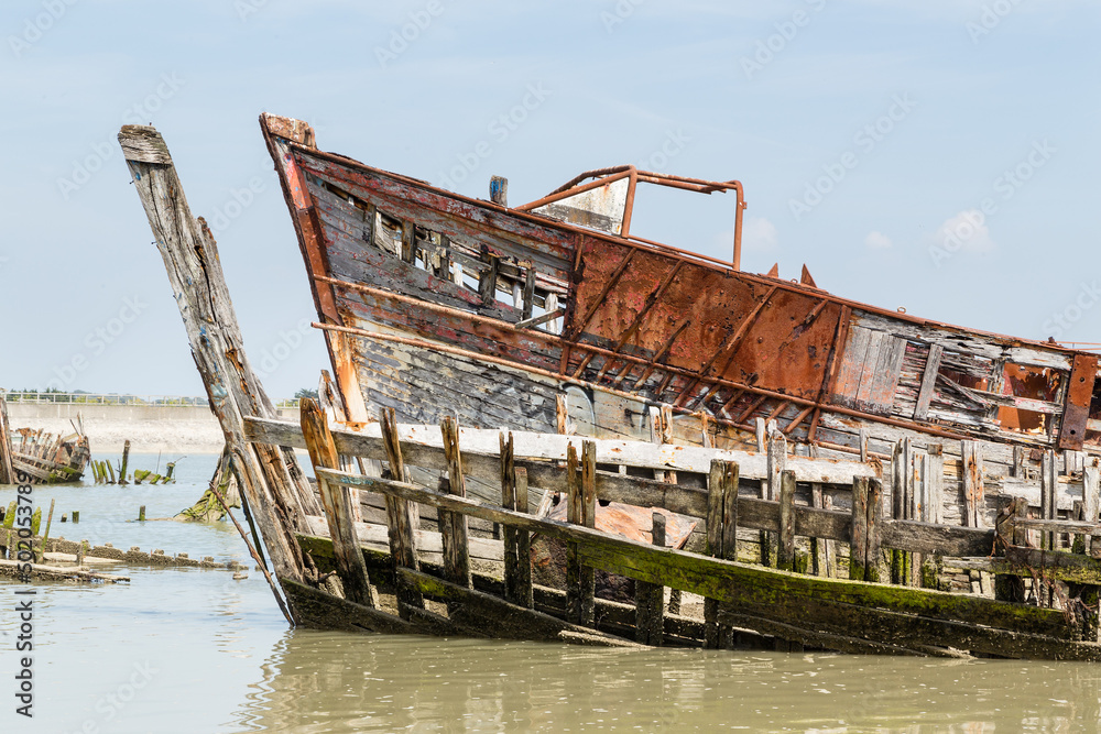 Cimetière marin, vieux bateaux en bois abandonnés dans le chenal d'un port, île de Noirmoutier Cimetière marin, vieux bateaux en bois abandonnés dans le chenal d'un port, île de Noirmoutier
