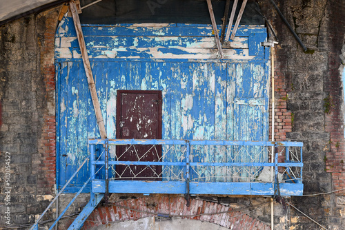 Fotografija Close-up of an old boathouse with peeling blue wall and a wooden ladder, Nervi,