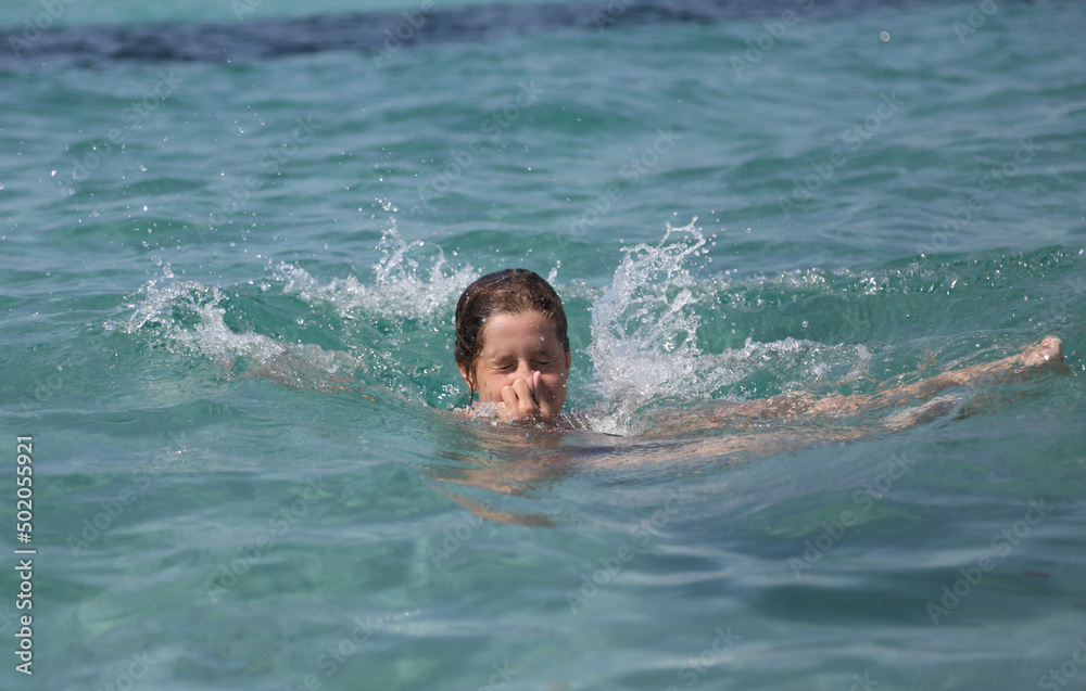 Little girl with head underwater in summer