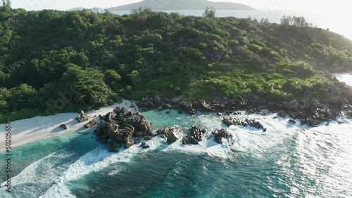 Aerial slider above end of Anse Cocos beach of east part of La Digue