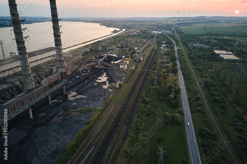 Aerial view of coal power plant high pipes with black smokestack polluting atmosphere. Electricity production with fossil fuel concept © bilanol