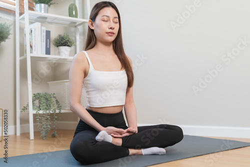 Routine health wellbeing concept. Woman doing meditation at home for practice her mindfulness pose lotus hand and breathing care.