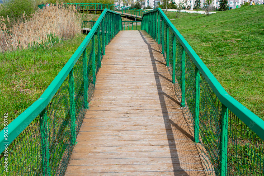 Boardwalk in the park. Walking path in the city park for recreation. Environment protection. Protective environmentally friendly structures and structures.