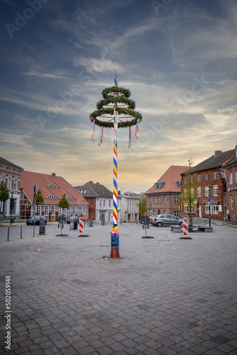 colorfully decorated maypole stands on a marketplace