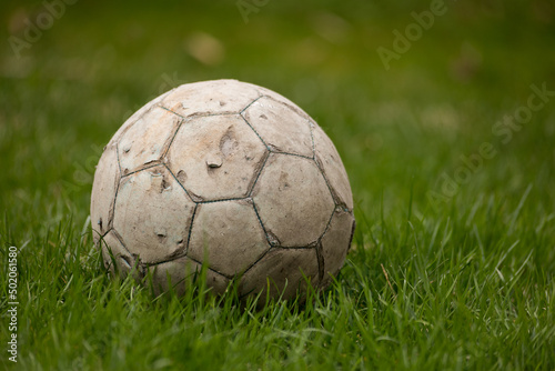 old soccer ball on grass © Marcin