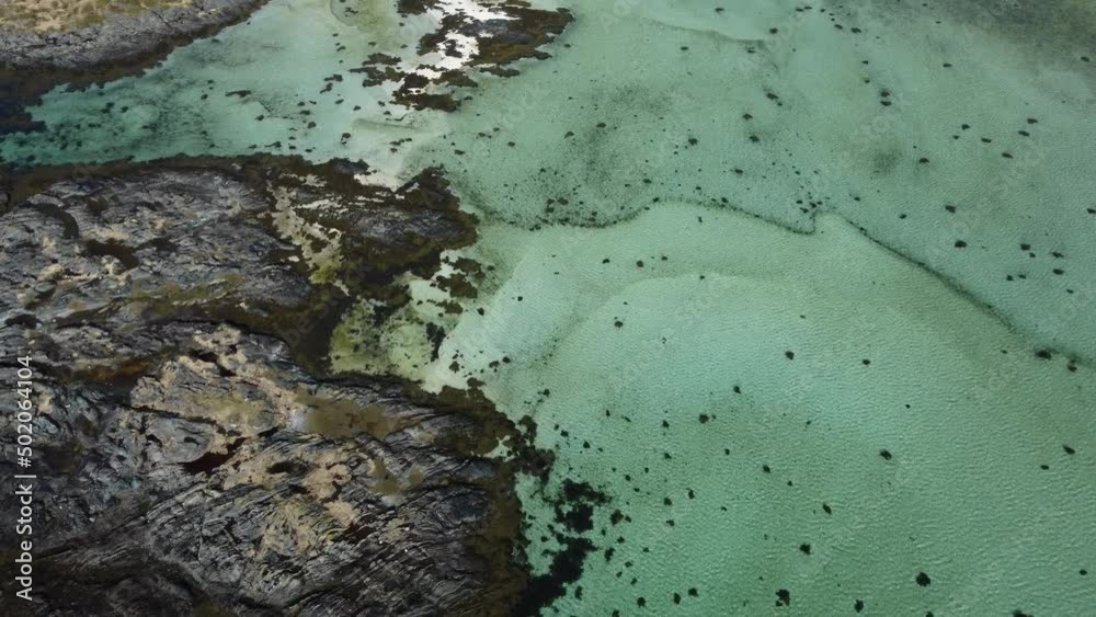 flying over green clean ocean fjord with vibrant sandy bottom and steep cliff sides flying over green clean ocean fjord with vibrant sandy bottom and steep cliff sides